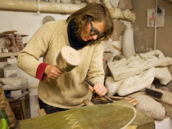 Eine Frau arbeitet in der Steinmetzwerkstatt