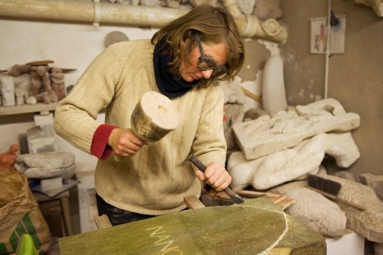 Eine Frau arbeitet in der Steinmetzwerkstatt