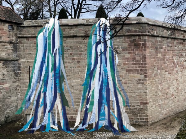 Lost & Found 2 – ein Kunstparcours im Burggraben - Linda Männel & Jan Vormann Bunte Bänder hängen von der Burgmauer in den Burggraben hinab