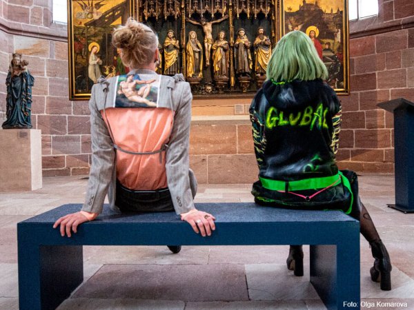 Global Art Festival - Olga Komarova Ein junger Mann und eine junge Frau sitzen auf einer Bank in der Kartäuserkirche