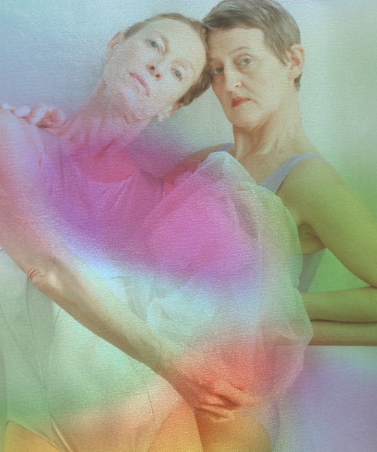 Alexandra Rauh und Susanna Curtis sich umarmend hinter Regenbogenfarben