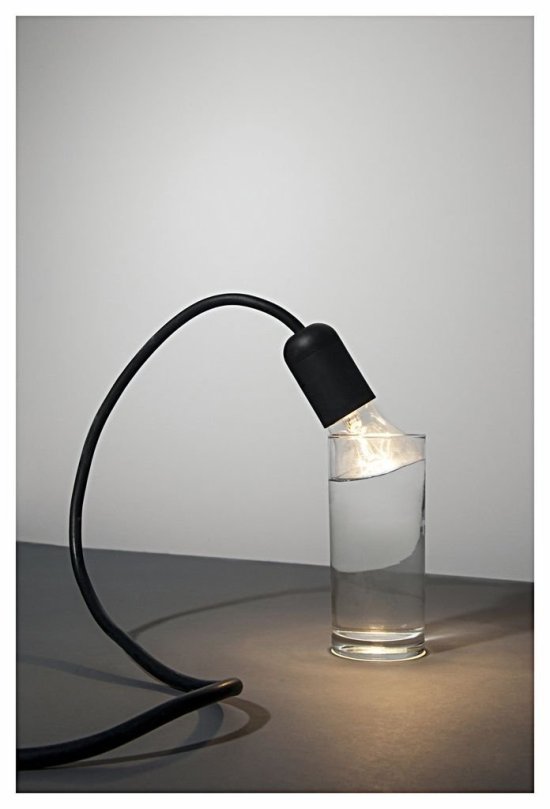 Foto einer Glühlampe, die in ein Wasserglas eintaucht und dabei eine optische Täuschung erzeugt
