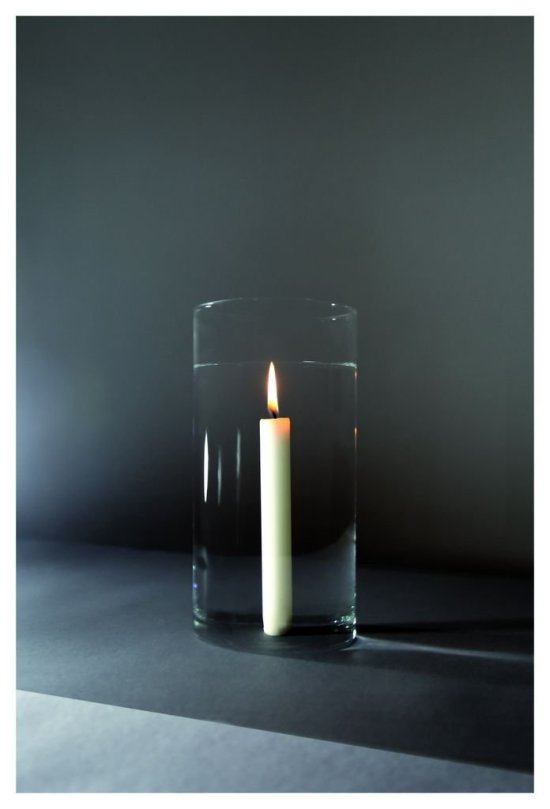 Foto einer brennenden Kerze, die scheinbar in einem Glas Wasser steht