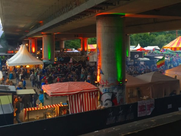 Zelte und Publikum unter einer Brücke.