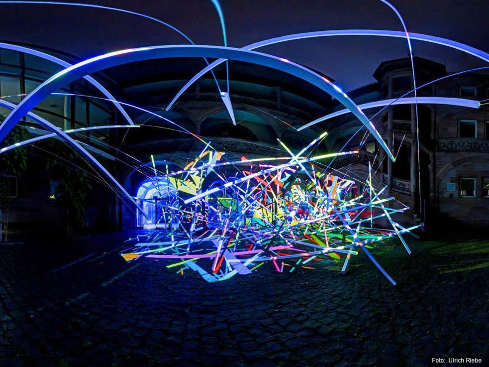 Blaue-Nacht-Kunstwettbewerb 2023 - Geschäftsbereich Kultur Abstrakte Stäbe und Lichtstrahlen in einem nächtlichen Innenhof.