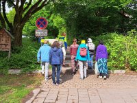 Acht Personen laufen zusammen einen Weg entlang.