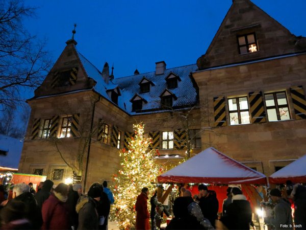 Stimmungsvoller Weihnachtsmarkt - Kulturladen Schloss Almoshof Stände des Weihnachtsmarkts und ein Christbaum im Innenhof von Schloss Almoshof