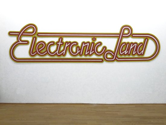 Neon-Werbeschrift eines Elektronikfachhandels in Holz nachgebaut