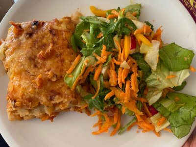 Lasagne mit Salatbeilage auf einem Teller angerichtet