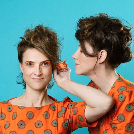 Brustbild zweier Frauen, eine frontal, eine im Profil; tragen orangegemusterte Kleider