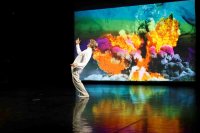 Henrik Kaalund vor einer Projektion mit bunten Rauchwolken