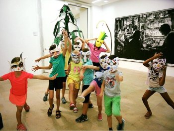 Tanzende Kinder in lustigen Masken beim Workshop