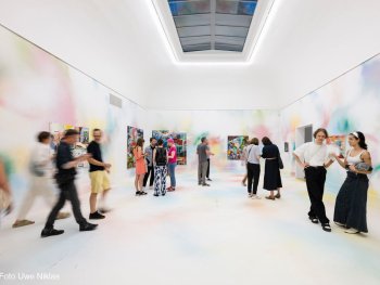 Raum zwei mit den in Pastelltönen besprühten Wänden und Boden, an den Wänden großformatige Gemälde