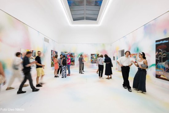 Raum zwei mit den in Pastelltönen besprühten Wänden und Boden, an den Wänden großformatige Gemälde