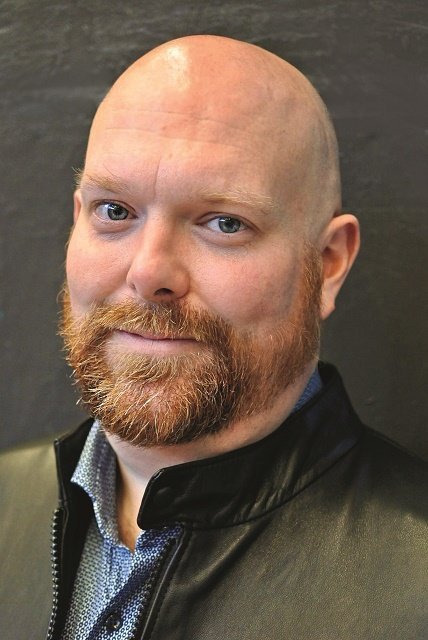 Mann mit Glatze und rotem Bart, freundlich lächelnd