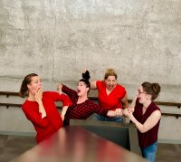 vier Frauen in ausgelassener Stimmung, rot gekleidet