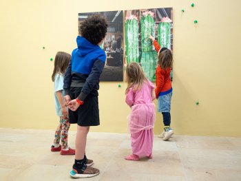 Kinder, die einen Fotodruck betrachten, der Riesenkakteen zeigt