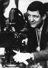 Foto des Regisseurs Eberhard Fechner, der beim Filmdreh neben einer Kamera steht