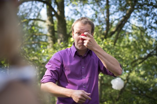 Mann mit roter Clownsnase im Freien