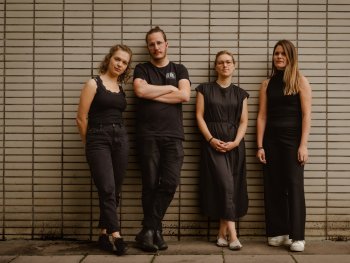 Foto: David Wegmann
Drei Frauen und ein Mann stehen ganz in schwarz gekleidet vor einer Wand gelehnt und schauen in die Kamera.