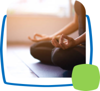 Person in Meditationshaltung auf der Yogamatte