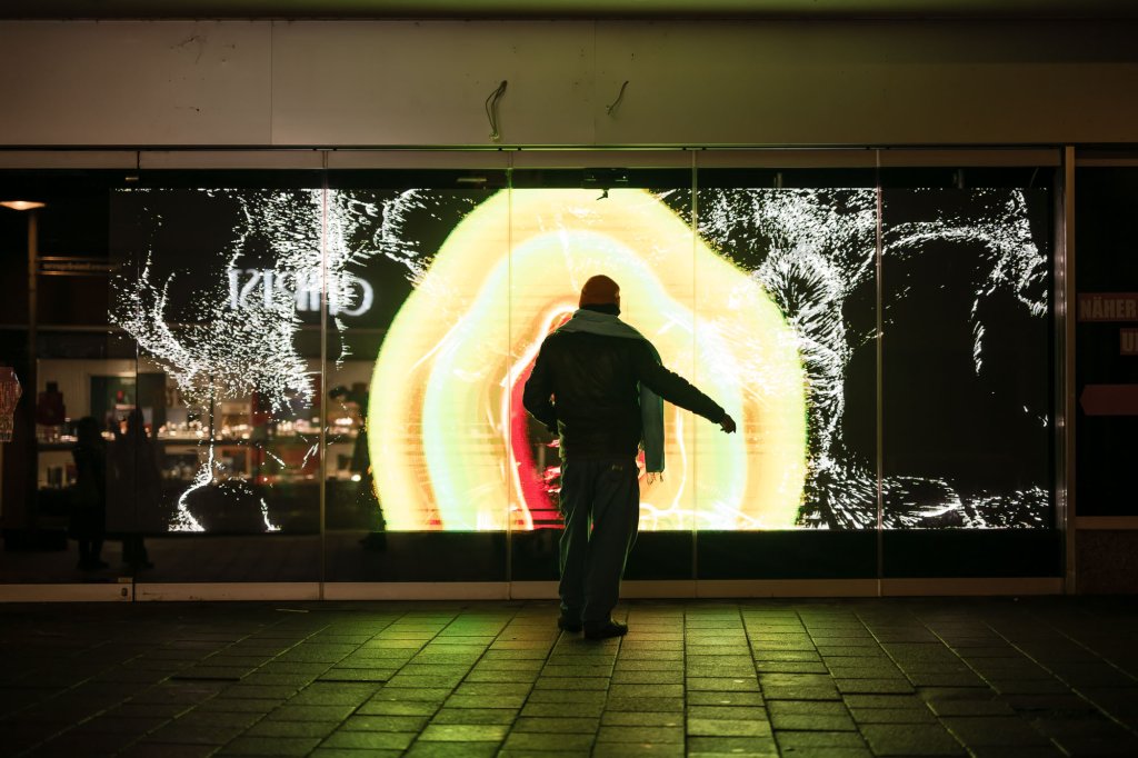 Eine Person steht vor einer Videoinstallation