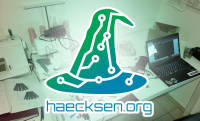 Logo der Haecksen, im Hintergrund ein Schreibtisch mit Computer, Nähmaschine und Werkzeug