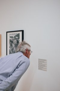 Ein Mann beugt sich zur Bildbeschreibung hin.