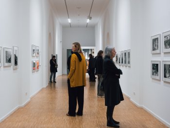 Menschen im Gang des Kunsthauses betrachten die Fotografien.