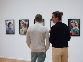 Foto: Laura Michele Kniesel
Zwei Menschen unterhalten sich vor Bildern von Hollywood-Berühmtheiten