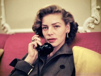 Schauspielerin Lauren Bacall telefoniert auf einer roten Couch sitzend