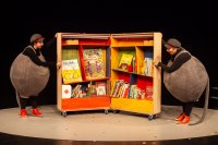 Lizzy und Lissy stehen rechts und links neben einem Bücherregal