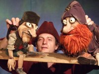 Zwei Piraten sitzen auf einem Brett und werden vom Puppenspieler in der Mitte gehalten.