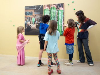 Vier Kinder und eine Kunstvermittlerin in Betrachtung eines Bildes