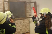 Kinder in Feuerwehruniform üben einen Feurwehreinsatz