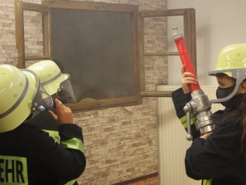 Copyright: Kindermuseum Nürnberg Kinder in Feuerwehruniform üben einen Feurwehreinsatz