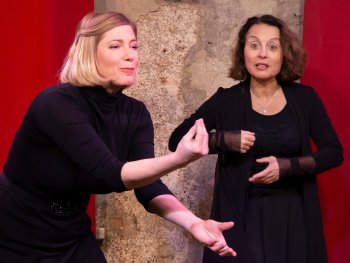 Copyright: Gabi Altenbach & Erika Honsel zwei Frauen, in schwarz gekleidet, gestikulieren auf Bühne