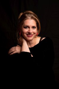 Porträt der Erzählerin, mit roten Ohrringen, lächelt in Kamera