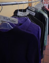 an einem Kleiderständer hängt Kleidung auf Bügeln