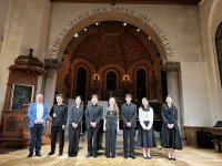 Acht Menschen in Abendgarderobe stehen auf Bühne