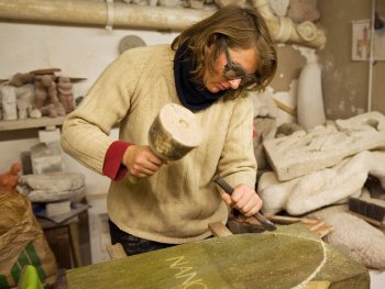 Copyright: Ralf Lang
Eine Frau arbeitet in der Steinmetzwerkstatt