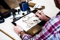 Person zeichnet das Porträt eines Mannes