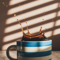 schwarzer Kaffee spritzt aus einer Tasse