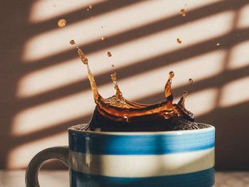 schwarzer Kaffee spritzt aus einer Tasse