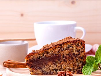 Foto: Stadt Nürnberg MAM-Db
ein Stück Kuchen auf einem Holzteller, dahinter eine weiße Tasse auf Unterteller