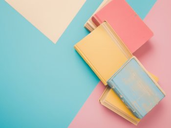 Bücherstapel auf pastelligem Untergrund