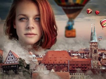 Der Kopf einer Frau schwebt über der Skyline von Nürnberg.