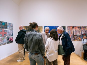 Der Künstler Lajos Keresztes (Mitte) im Gespräch mit Besuchern der Vernissage