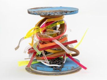 Copyright: Sebastian Kuhn, Beauty Trophy, 2026 zeitgenössischer Pokal bestehend aus zwei blauen Metallscheiben, die eine Stange halten. Die Stange ist mit bunten Kunststoffbändern und einer Fahrradkette umwickelt.