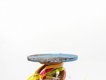 Foto: Foto: Wolfgang Günzel, (c) Sebastian Kuhn & VG Bild-Kunst Bonn, 2026
zeitgenössischer Pokal bestehend aus zwei blauen Metallscheiben, die eine Stange halten. Die Stange ist mit bunten Kunststoffbändern und einer Fahrradkette umwickelt.